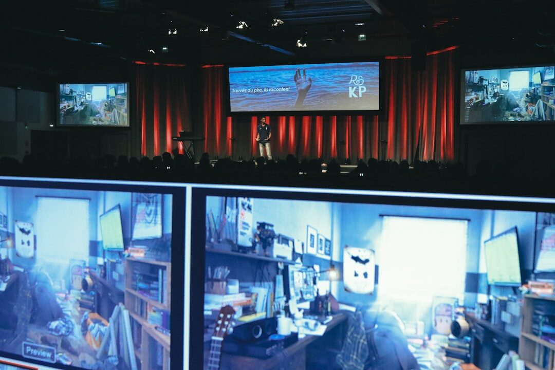 Modern newsroom with journalists working at desks with monitors displaying news